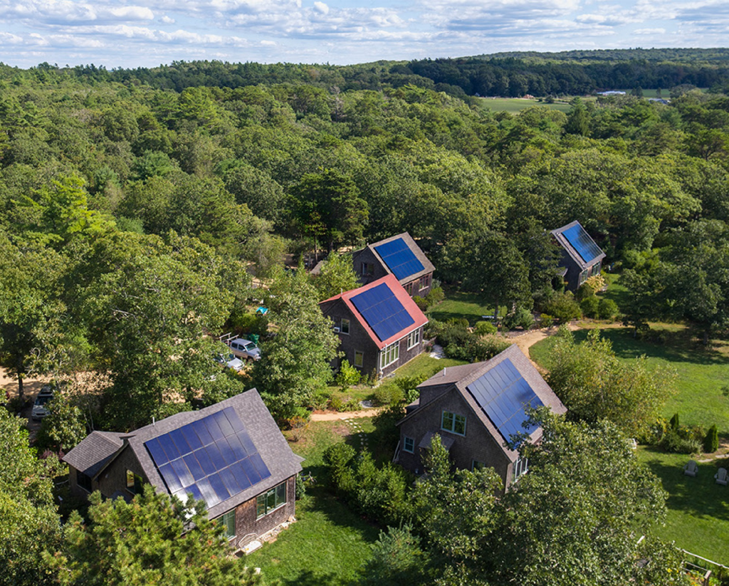 Solar panels on house roofs in a forest area.